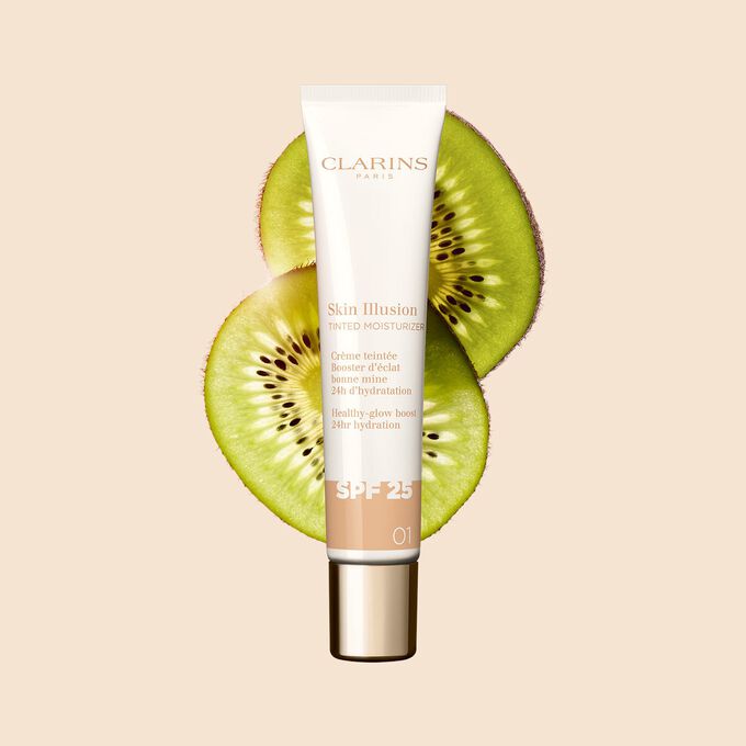 Packshot of the 40ml tube of Skin perfector Skin Illusion Tinted Moisturizer shade 01, placed next to kiwi slides