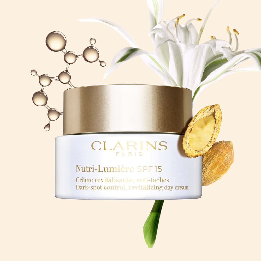  Packshot of the Nutri-Lumière SPF 15 anti-blemish cream alongside niacinamide molecule, sea lily plant, and desert date.