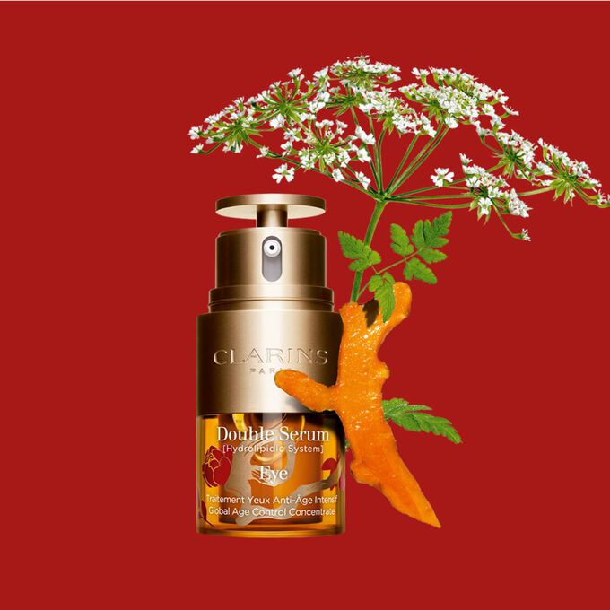 Packshot of Clarins Eye Double Serum Chinese New Year Limited Edition, placed next to a turmeric slice and a wild chervil flower.