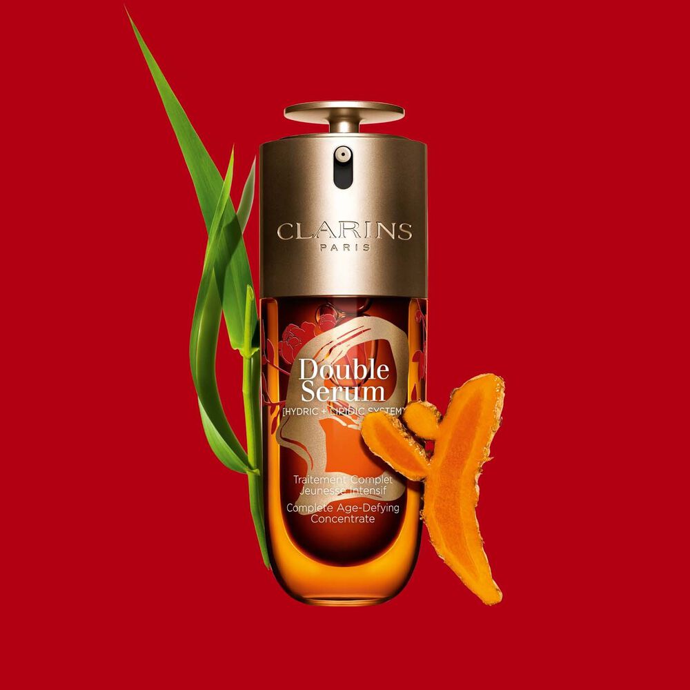 Packshot of Clarins Double Serum Chinese New Year Limited Edition with a turmeric slice on a red background.