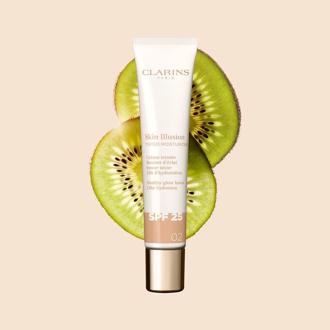 Packshot of the 40ml tube of Skin perfector Skin Illusion Tinted Moisturizer shade 02 placed next to kiwi slides