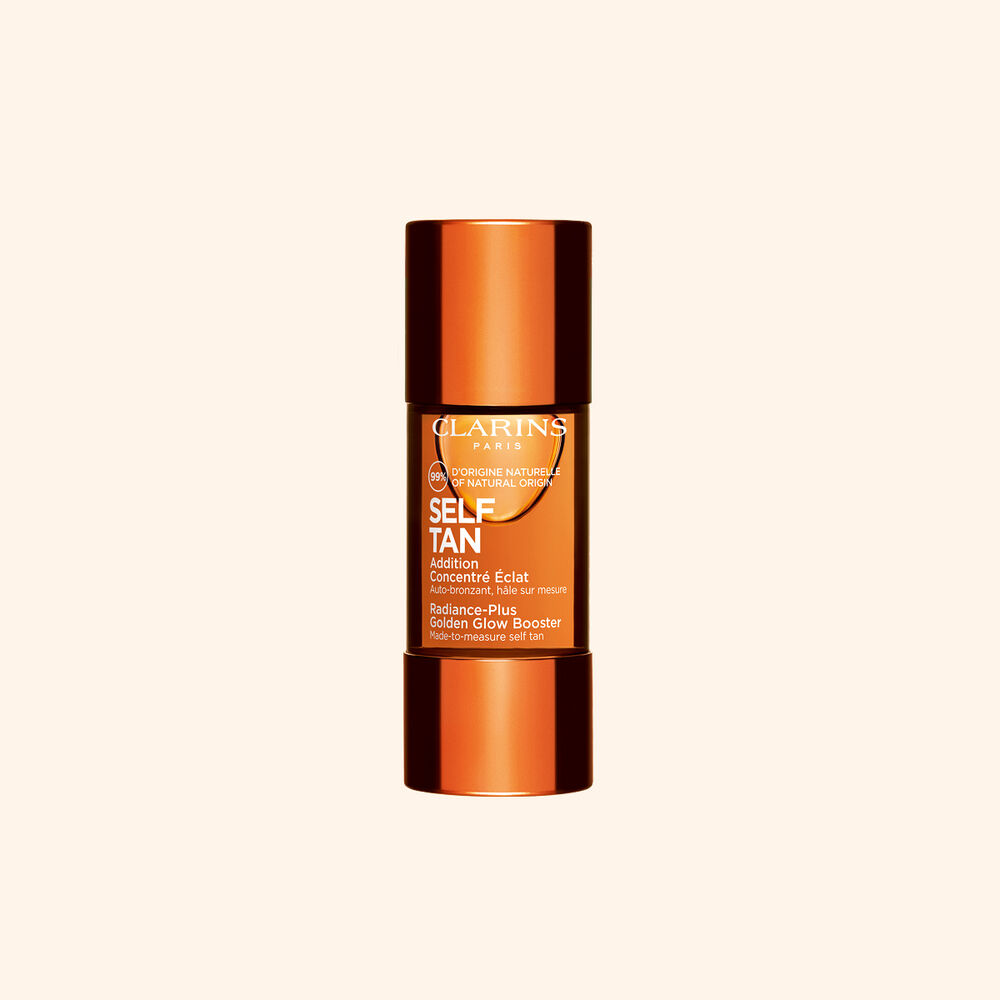 Clarins self tanning glow booster bottle displayed on a beige backdrop for a sun kissed radiant skin routine.