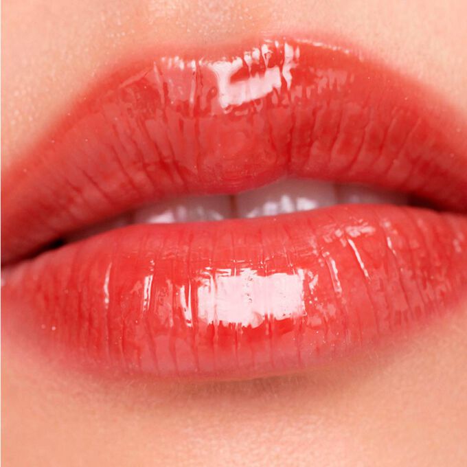 Close-up of lips wearing Clarins Lip Comfort Oil - Limited Edition in Bright brick shade, hydrating, plumping, and glossy.