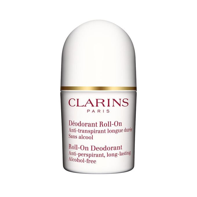 Packshot of a Deo roll-on for sensitive skin close to some blades of rosemary on a white background.