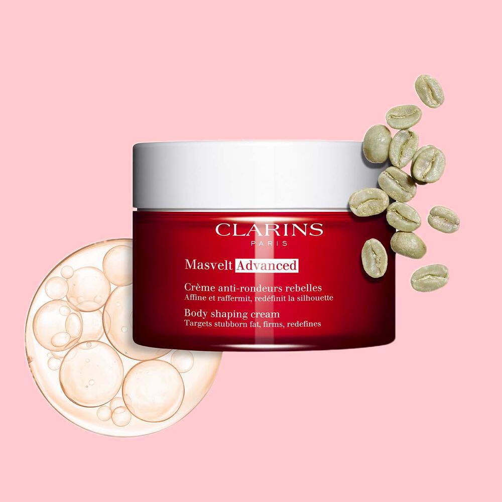 Packshot of Clarins Masvelt Advanced Body Shaping Cream close to coffee beans on a pale pink background.