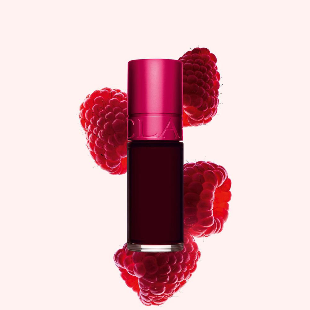 Packshot of Clarins Pink Water Lip Stain in shade 4, placed beside rasberries on a light pink background.