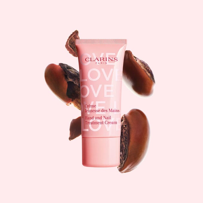 Packshot of Hand Cream Limited Edition Love Collection in front of shea seed on a light pink background, emphasizing its key ingredient