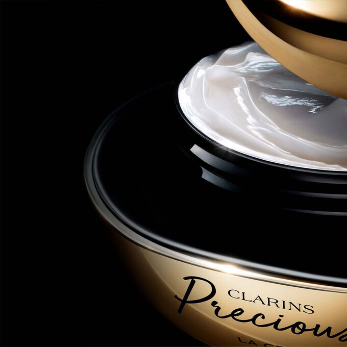 Packshot of Clarins Precious Soft Cream on dark background, with text emphasising its power to make skin appear 5 years younger