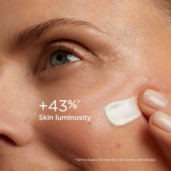 Woman with closed eyes, wearing SOS Primer White by Clarins on her face to illustrate that it reduces signs of fatigue by 20%