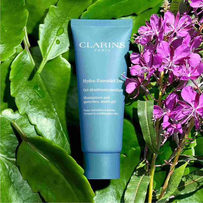 Packshot of Clarins Hydra-Essentiel Matte Gel among Alpine willowherb, highlighting its 92% natural origin ingredients.