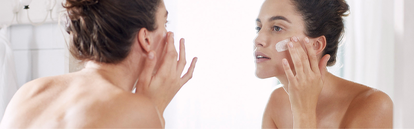 Woman moisturising her face