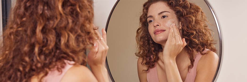 Woman putting cream on her face